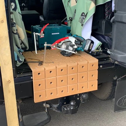 HDS portable workbench set up on the back of a Land Rover Defender with a Makita circular saw and hold down clamp, demonstrating use as a mobile workshop