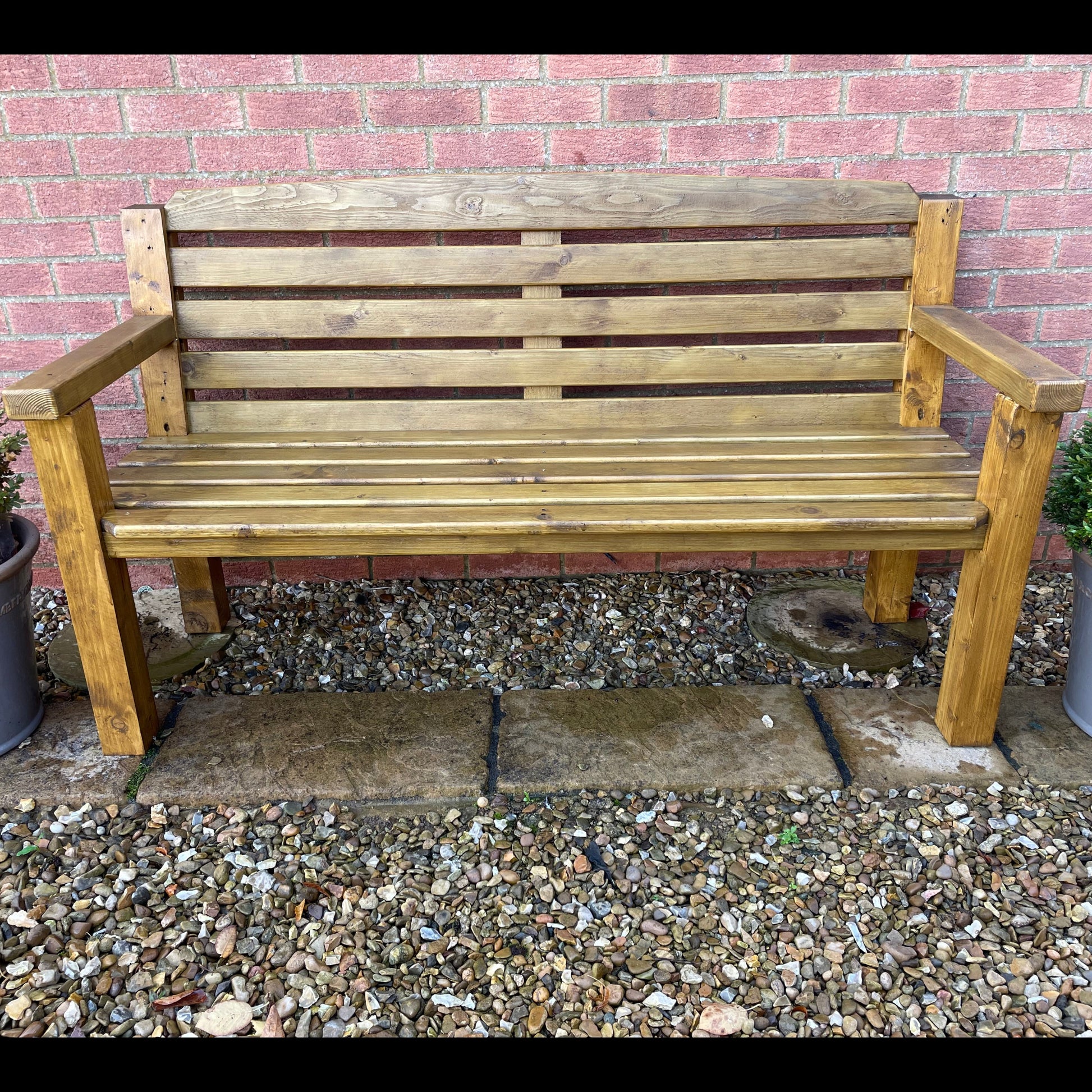 Garden bench in medium oak on a patio front on