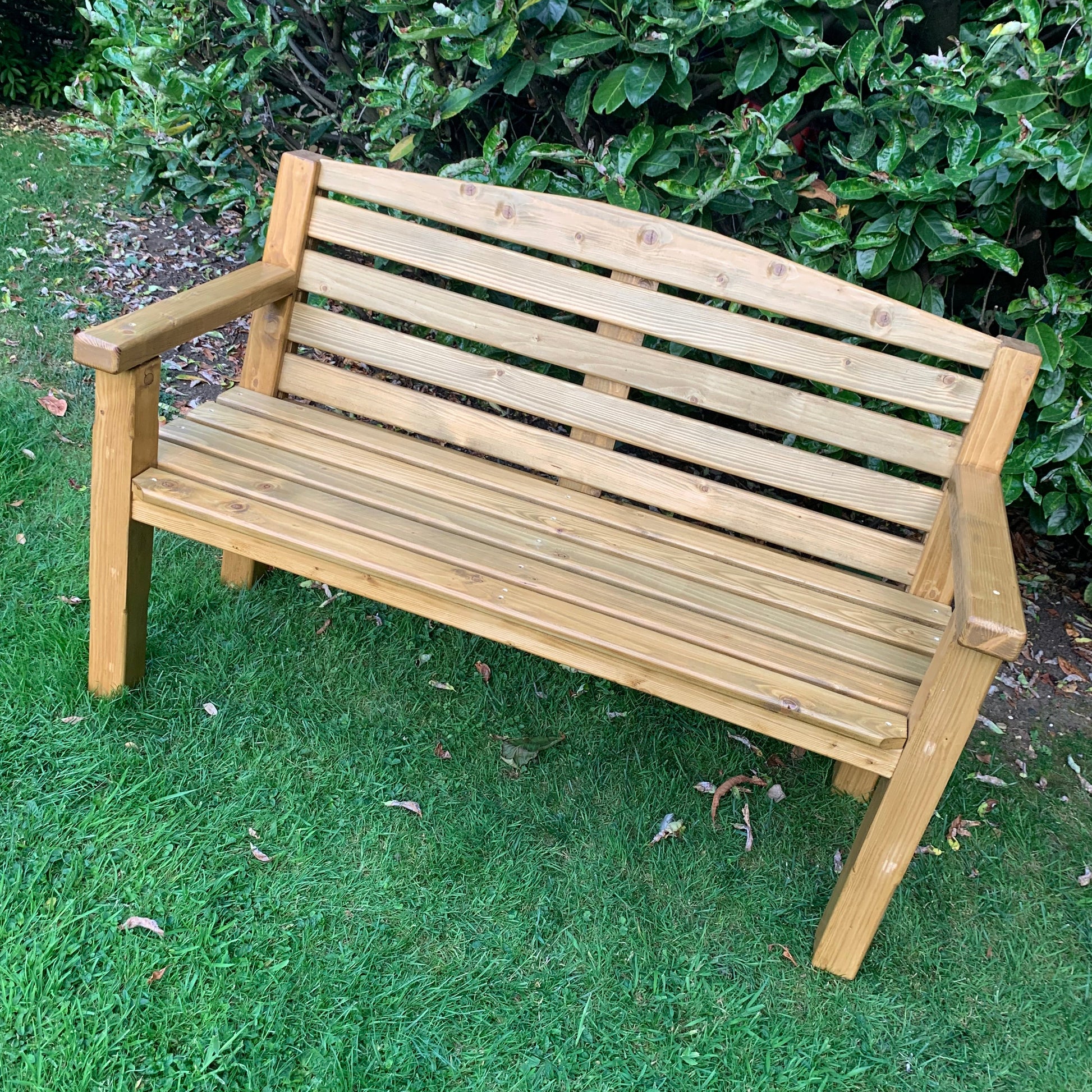 Medium oak garden bench on lawn, handmade by Whaley Woodworks