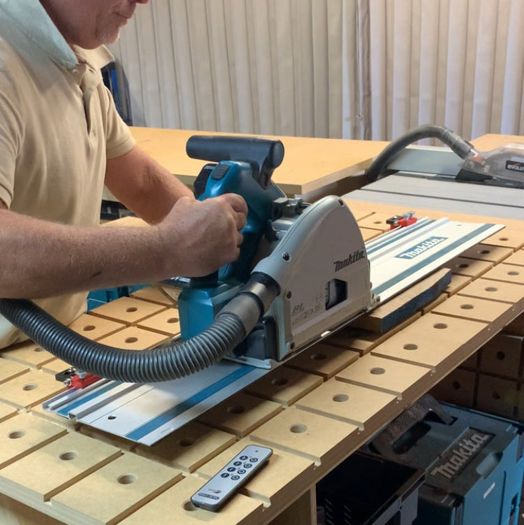 Woodworker using a track saw on timber positioned against HDS bench dog stops.