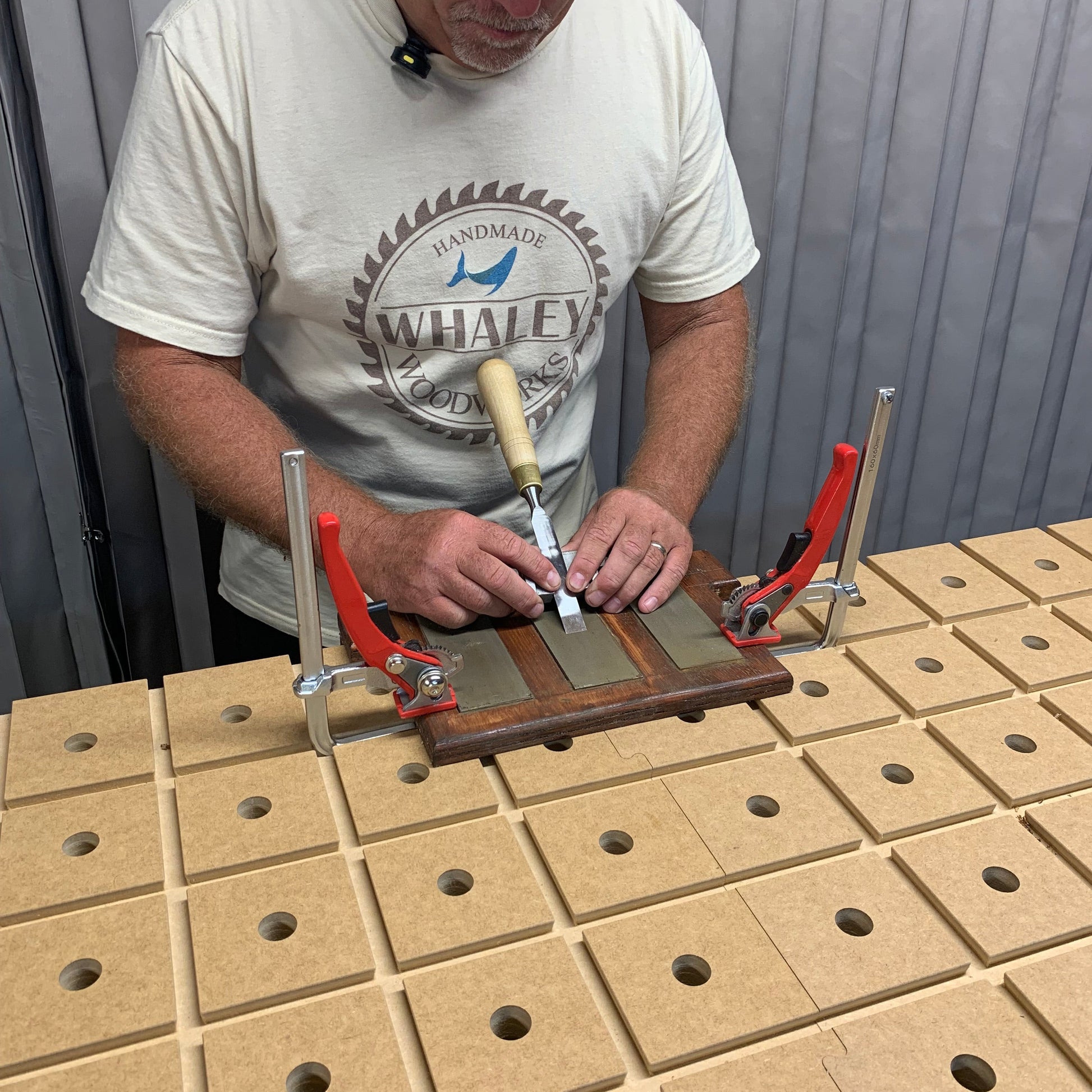HDS Workbench Top – woodworker sharpening chisels on a sharpening station clamped to the hold down system workbench top, made in the UK