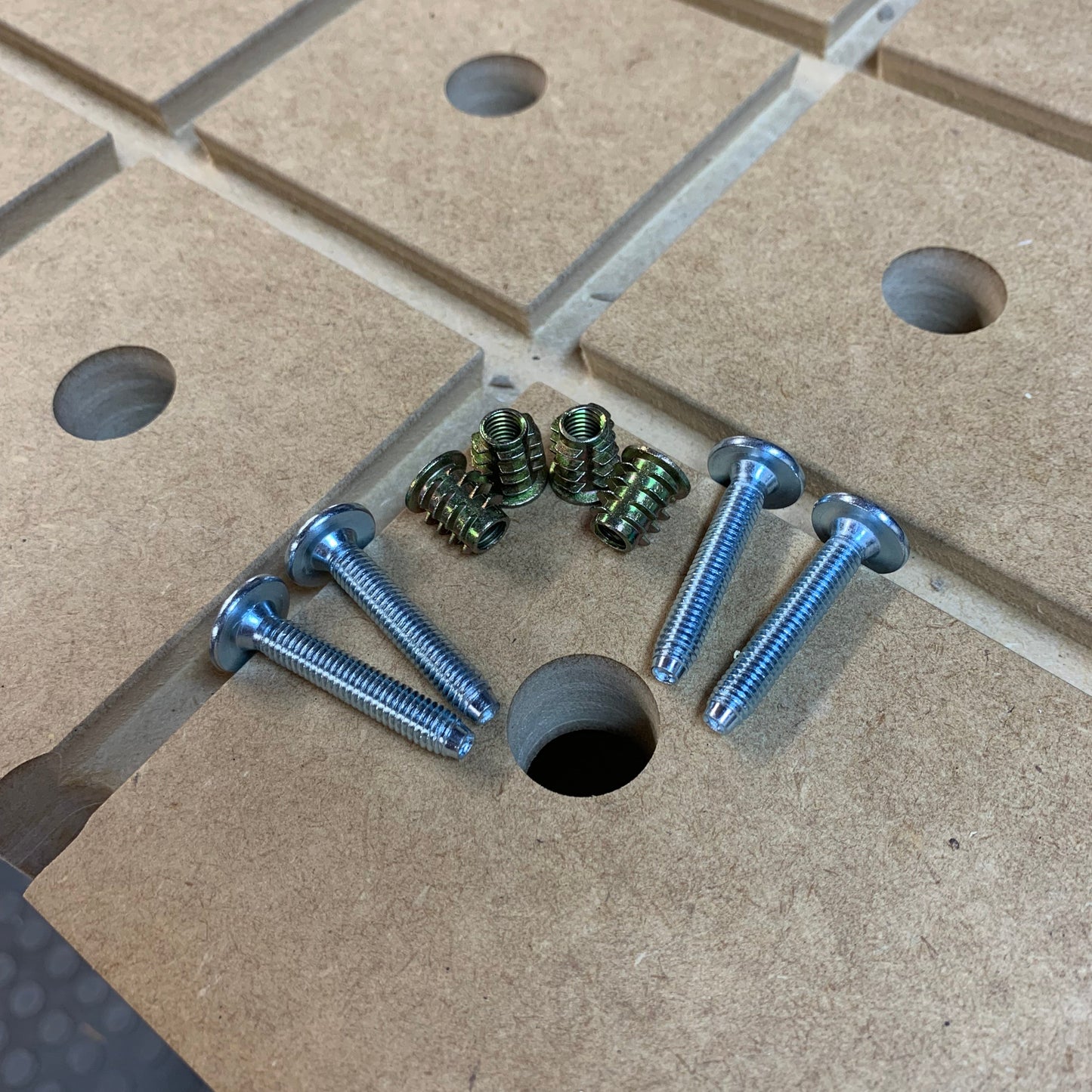 M6 button-top bolts and threaded inserts laid out on an HDS Workbench Top with dog holes, ready for installation