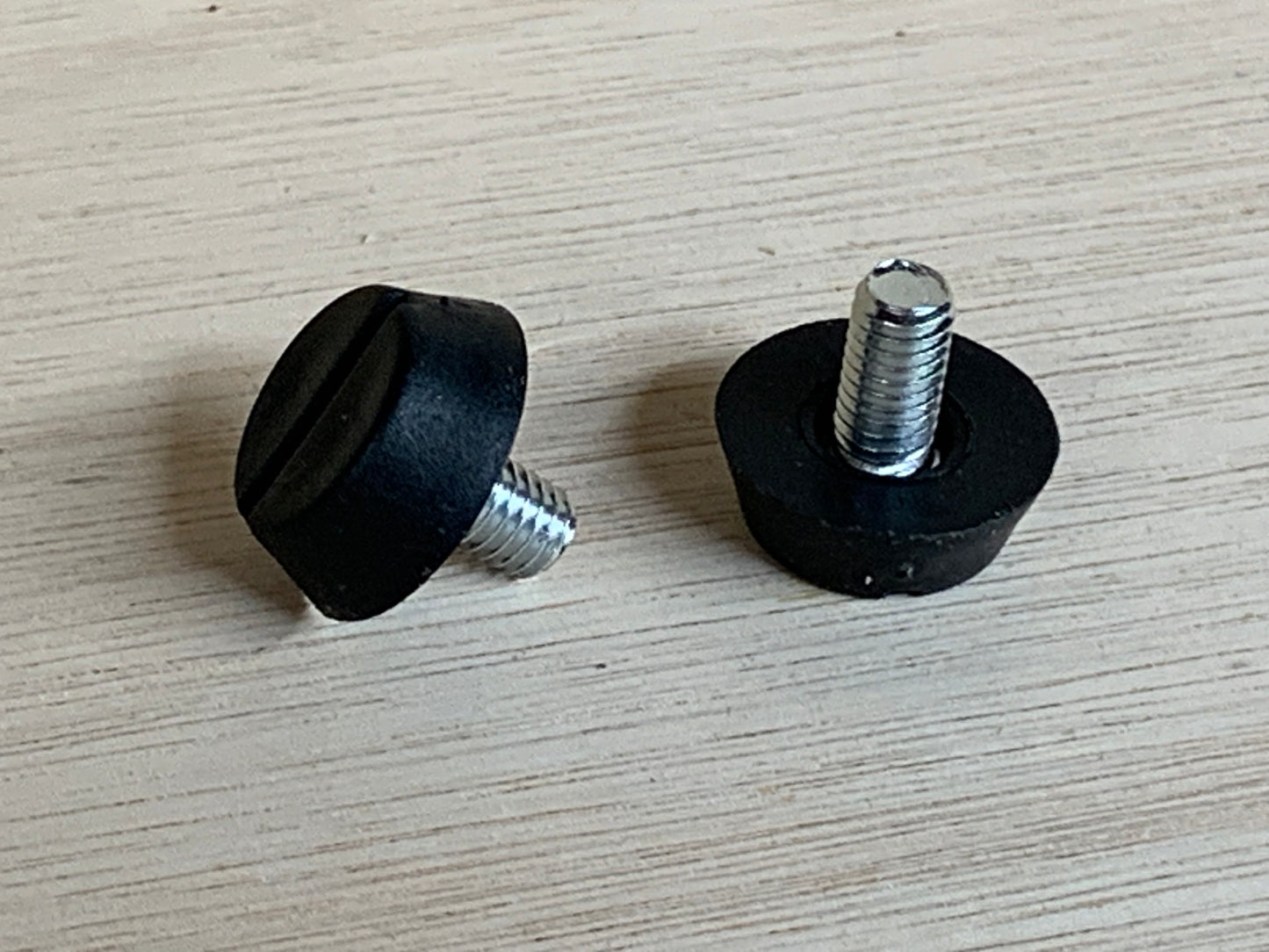 Two HDS Screw in anti slip plugs On a wooden surface