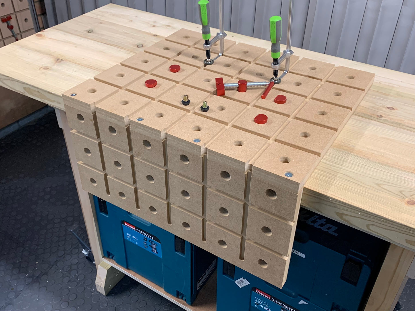 HDS hold down system on a workshop bench showing all the accessories that come with the elite pack including bench dogs and track clamps