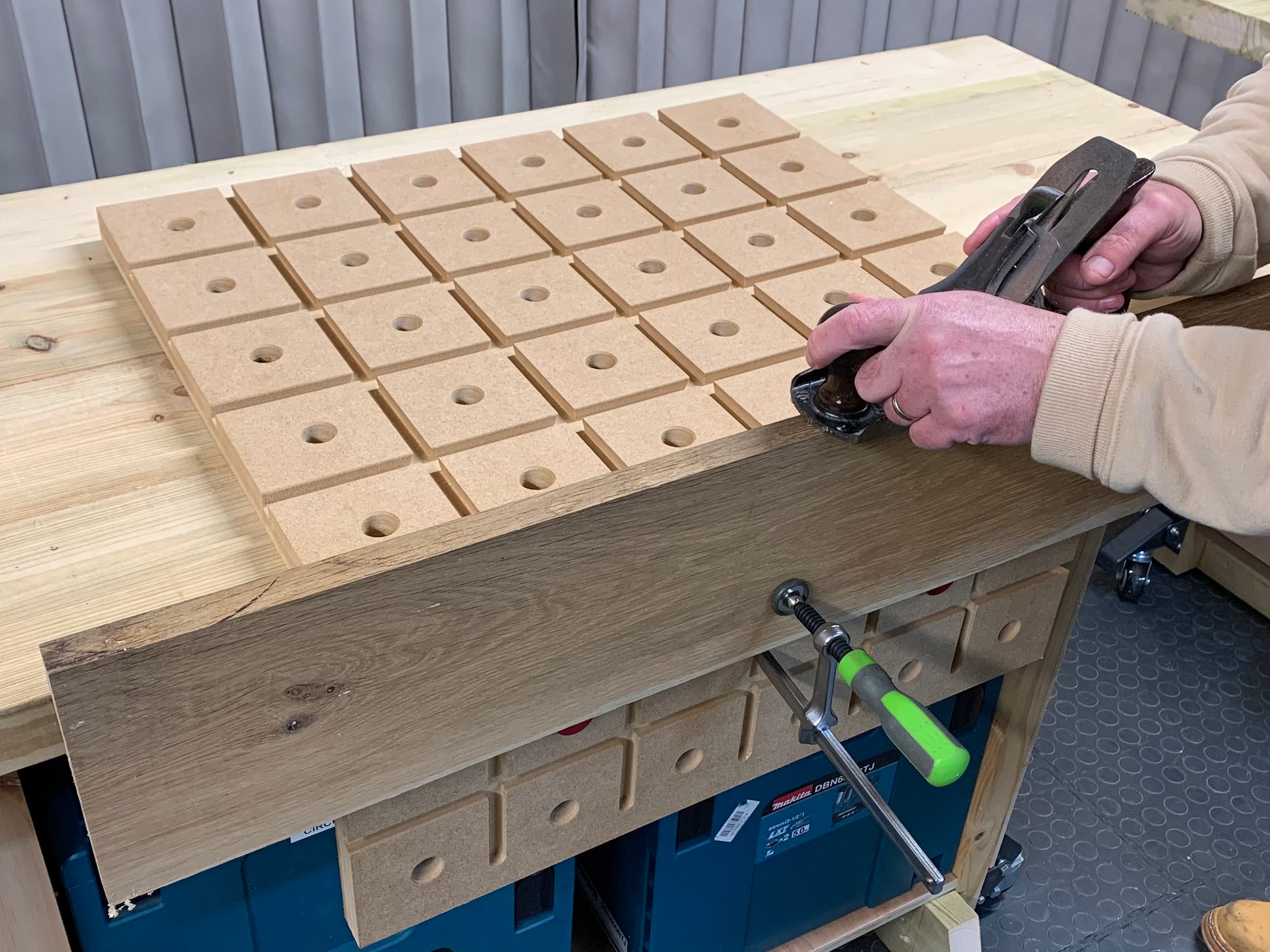 Woodworker using a standard track clamp on the HDS hold down system to plain material