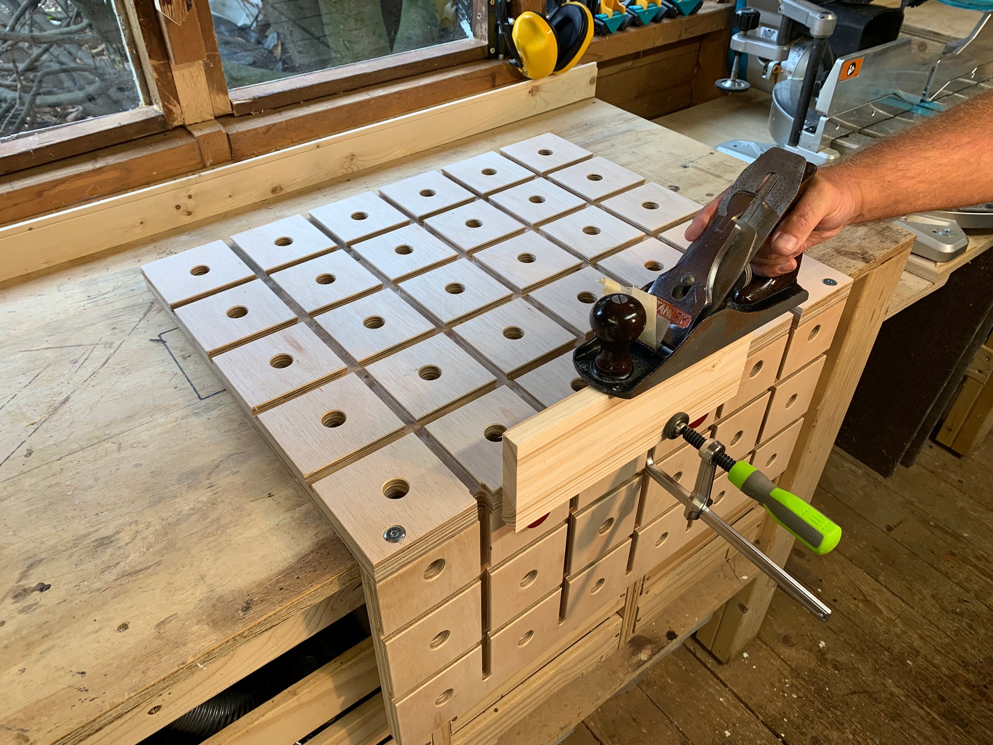 Planing wood using a hand plane and the Grade B HDS Hold Down System wooden workbench for DIY and woodwork enthusiasts
