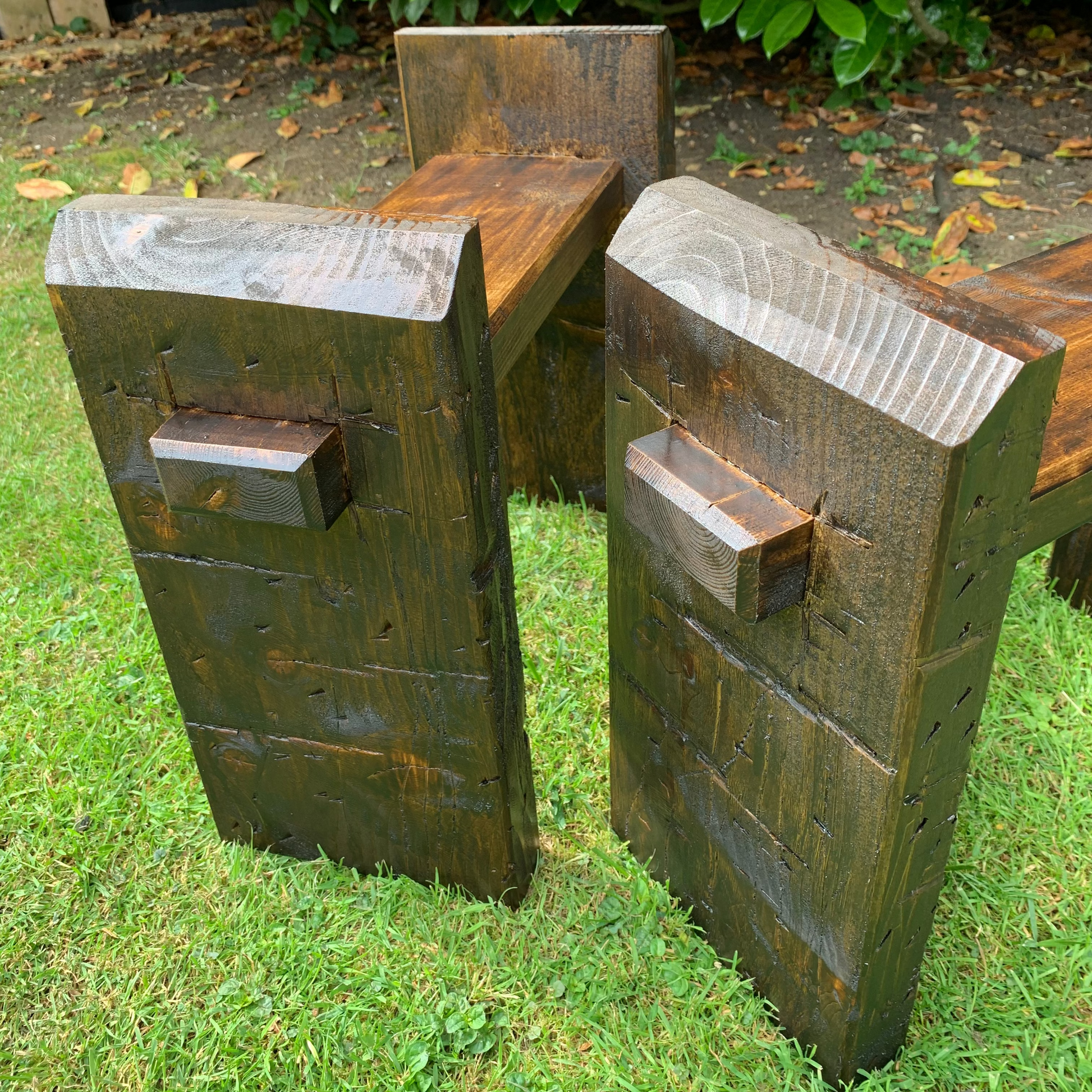 Dark oak sleeper bench legs pair on grass, Whaley Woodworks
